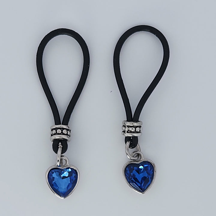 Two Rich Blue Heart Shaped Gem Nipple Nooses Against a White Background